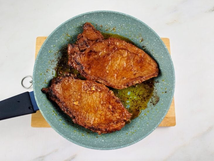 Bifes virados para dourar na frigideira.