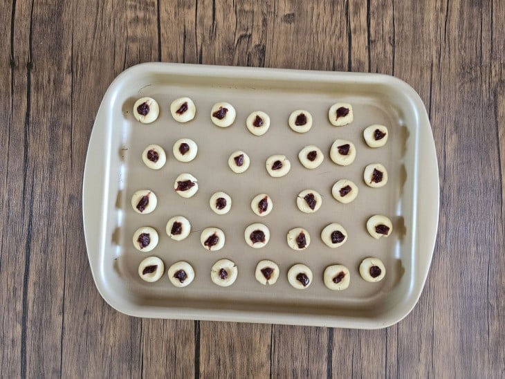 Uma assadeira contendo biscoitos amanteigados com goiabada.