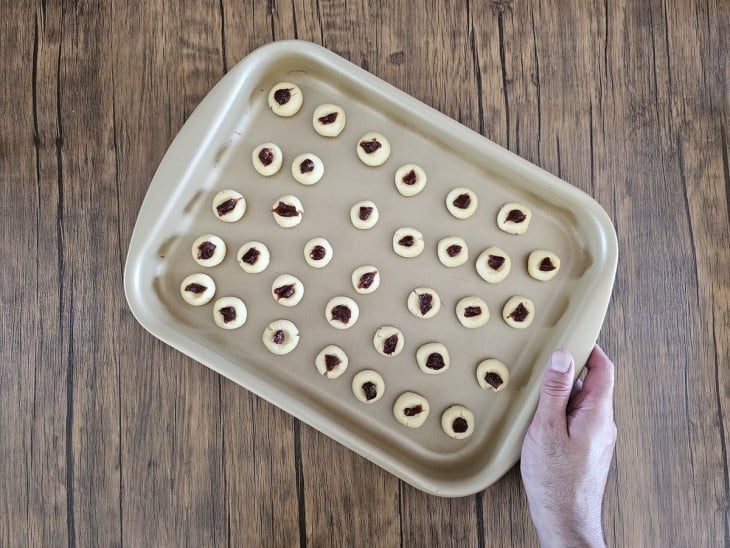 Uma assadeira contendo biscoitos amanteigados com goiabada.