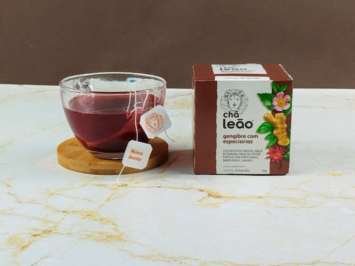 Sachê de chá em infusão em uma xícara de vidro.