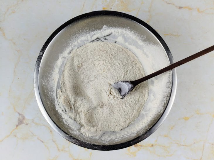 Tigela com farinha, sal, fermento e gengibre em pó peneirados.