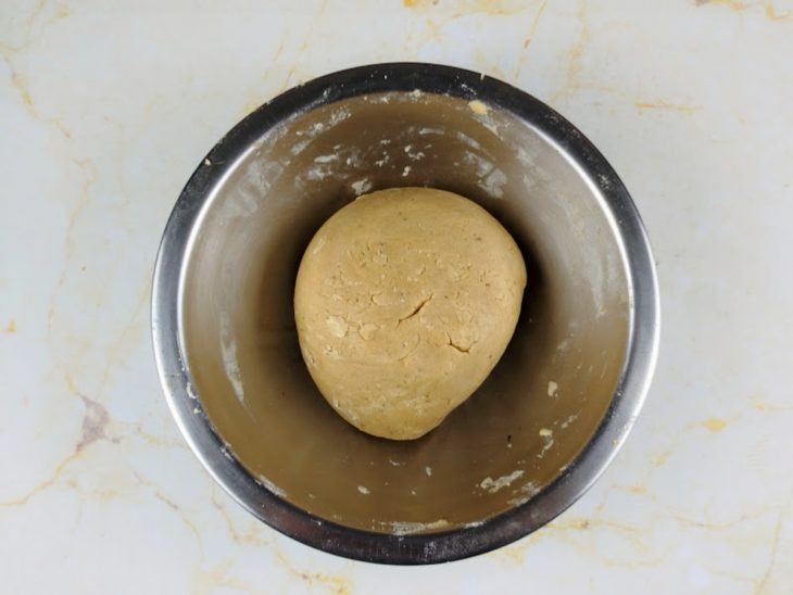 Mistura de ingredientes secos adicionada, aos poucos, a tigela com a massa.