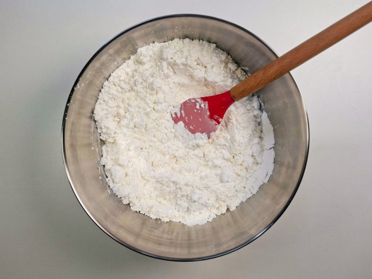 Leite e manteiga sendo incorporados formando farofa úmida.