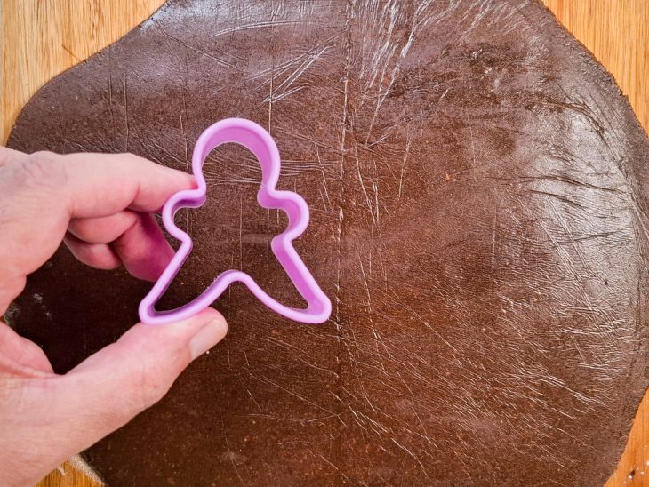 Na bancada, a massa já aberta, e o molde dos biscoitos em primeiro plano.