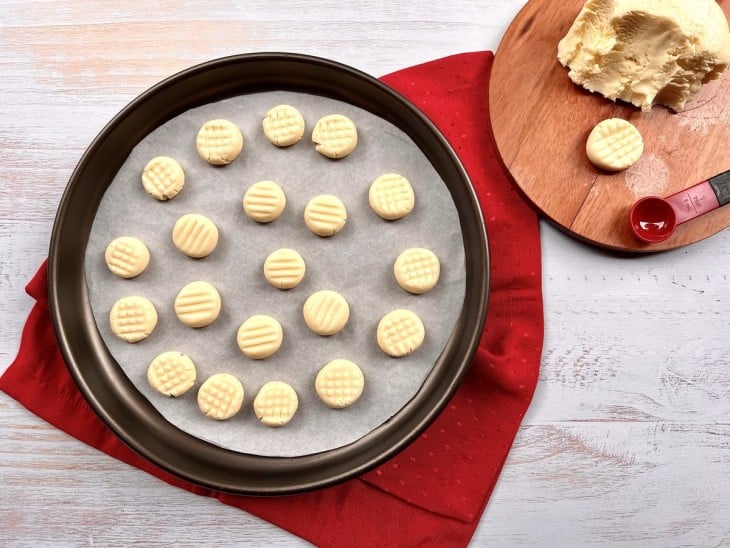 Uma forma com vários biscoitos crus.