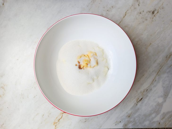 Numa tigela, a nata, a manteiga, o açúcar e a baunilha.