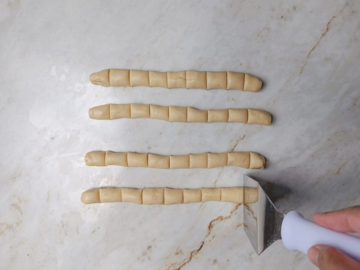 Na bancada, a massa cortada em cubinhos.