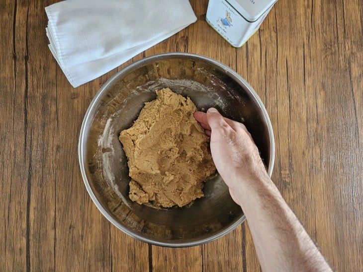 Mão amassando a massa do biscoito de Natal americano.