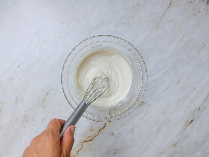 Glacê num recipiente mexido com um fouet.