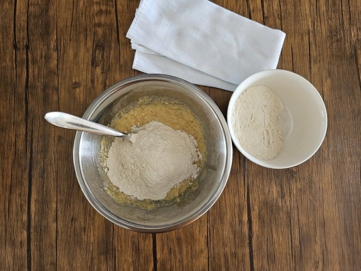 Um recipiente contendo a mistura de manteiga, açúcar, ovo, a farinha e as nozes trituradas.