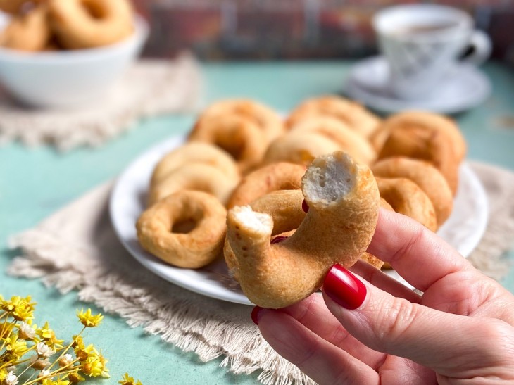 Um recipiente com vários biscoitos de polvilho doce frito.