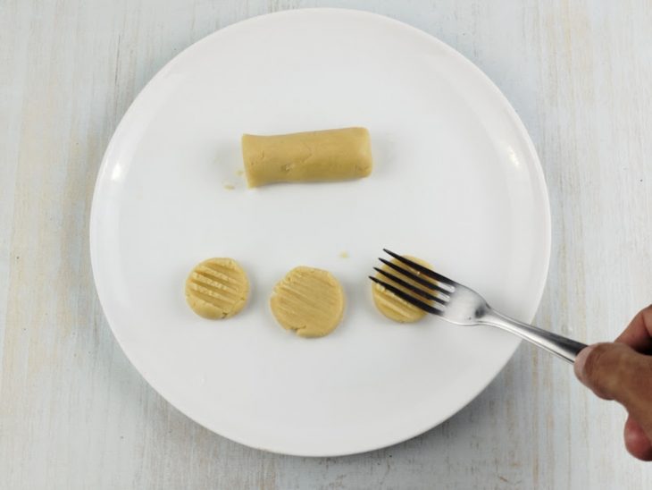 Garfo amassando a massa de biscoito.