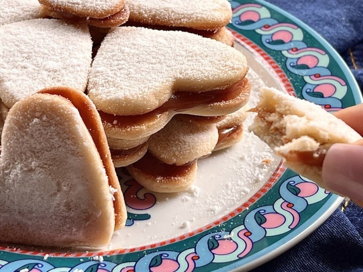 Um recipiente contendo vários biscoitos recheados de doce de leite.