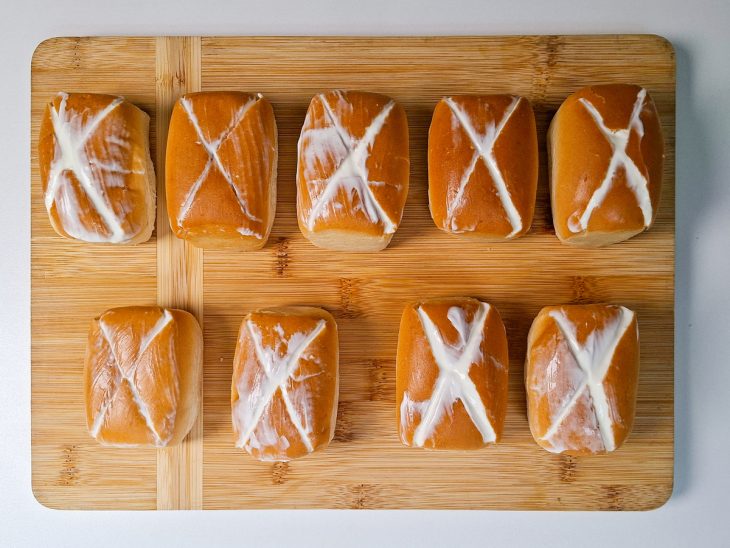 Creme sendo inserido nas aberturas dos pães com colher pequena.