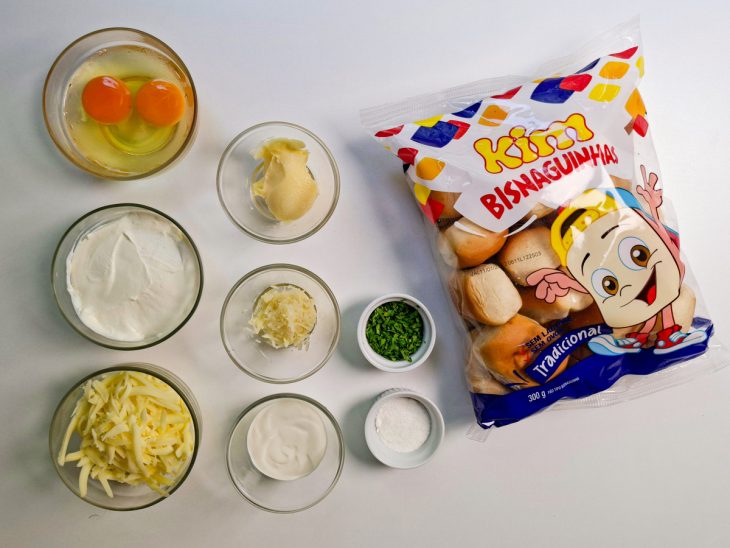 Ingredientes organizados sobre a bancada, com assadeira forrada ao fundo.