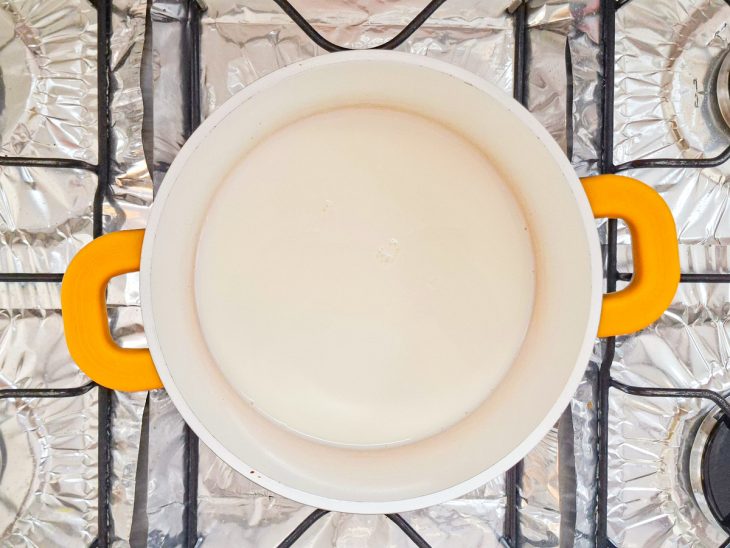 Panela com leite no fogo.