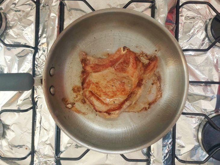 Bisteca de porco em uma frigideira.