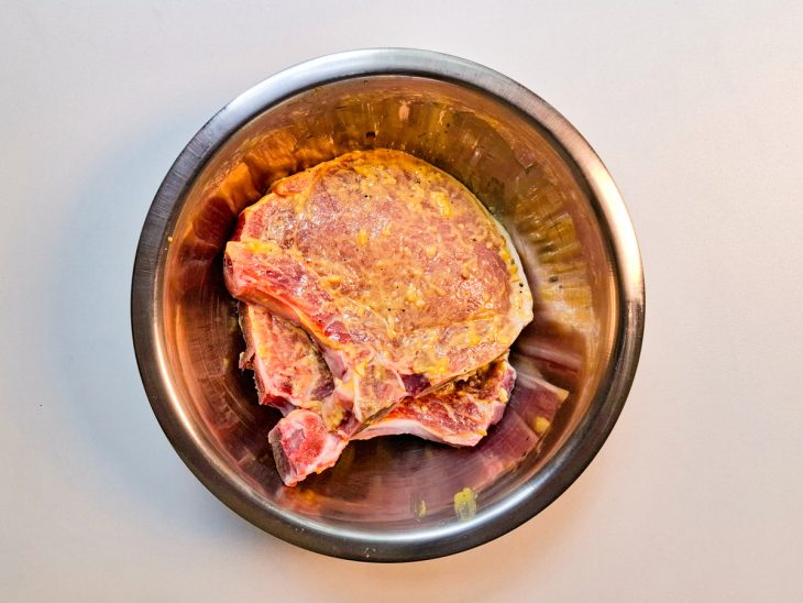 Na tigela, as bistecas marinando.