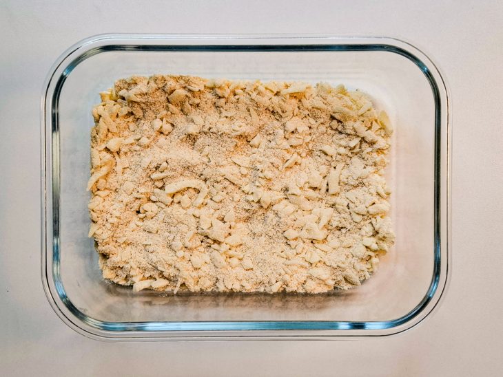 Numa travessa, a farinha de rosca e o queijo misturados.