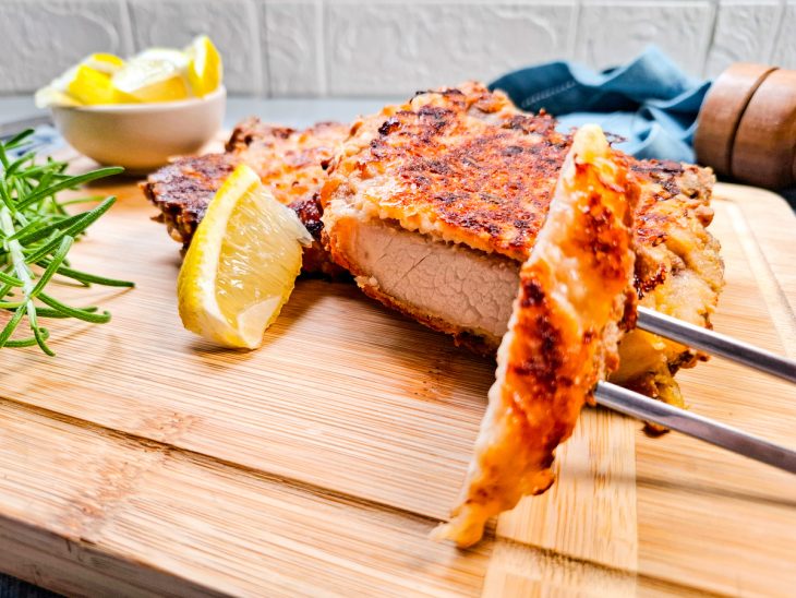 Bistecas prontas, servidas em tábua, uma delas cortada mostrando a textura.