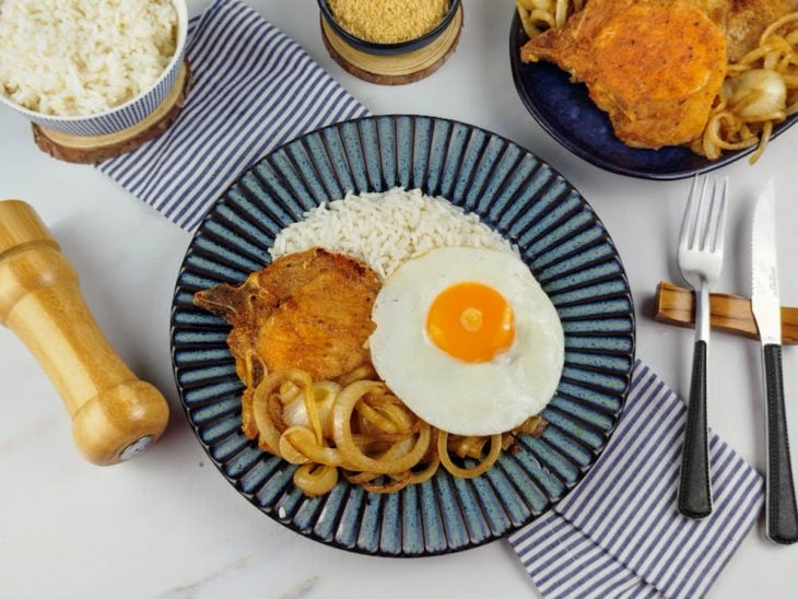 Bisteca fácil e rápida em um prato, acompanhada por arroz e ovo frito.