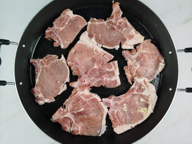 Bistecas acomodadas em uma frigideira.