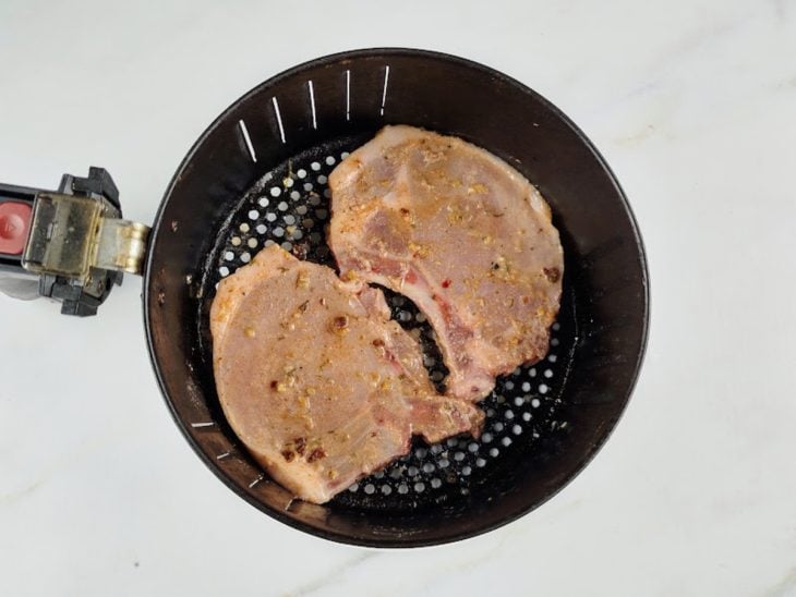 Bistecas pinceladas com azeite e levadas ao cesto da Air Fryer.