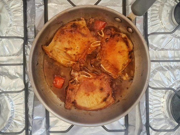 Bistecas com a pimenta e o molho na frigideira.