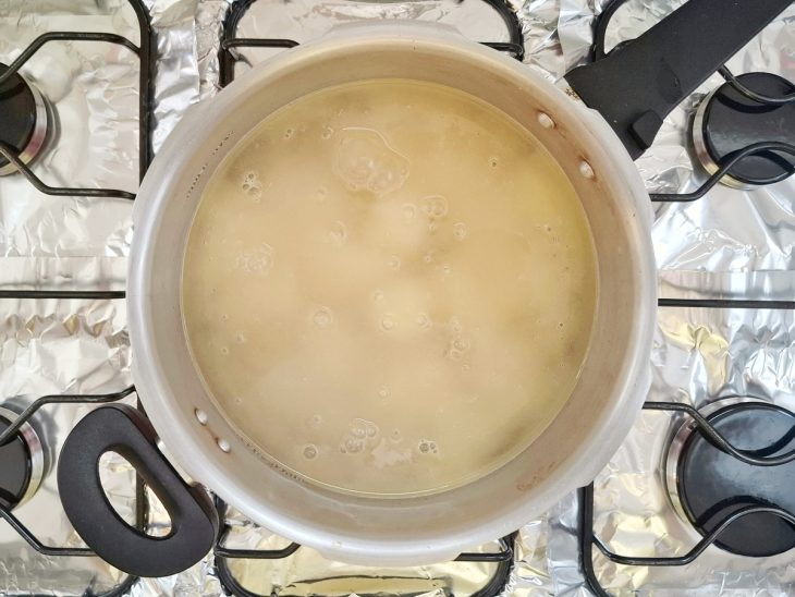mandioca cozinhando na panela de pressão