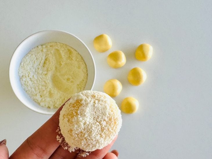 Bolinhas de massa polvilhadas com leite em pó.