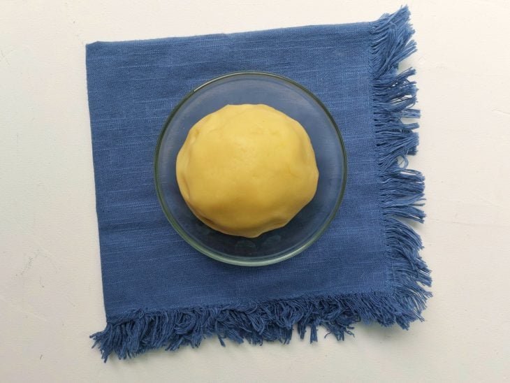 Um recipiente com a massa de bolinha de queijo após cozimento.