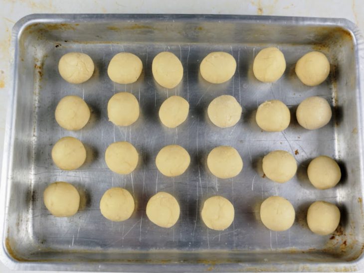Bolinhas modeladas e acomodadas em uma assadeira.