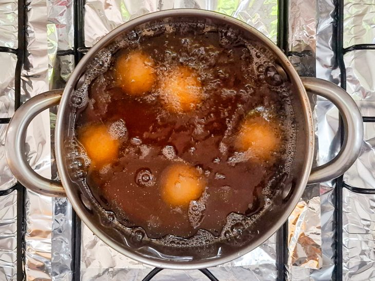 Bolinhas de queijo fritando em uma panela com óleo.