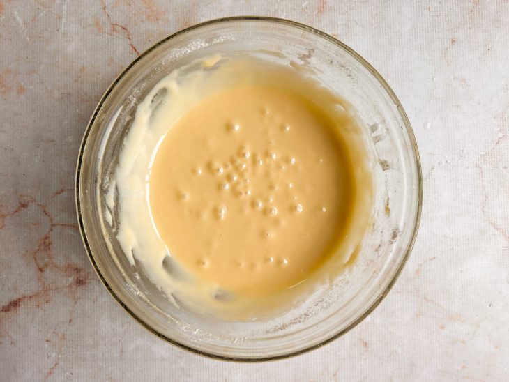 Leite condensado misturado à farinha peneirada até formar creme liso.