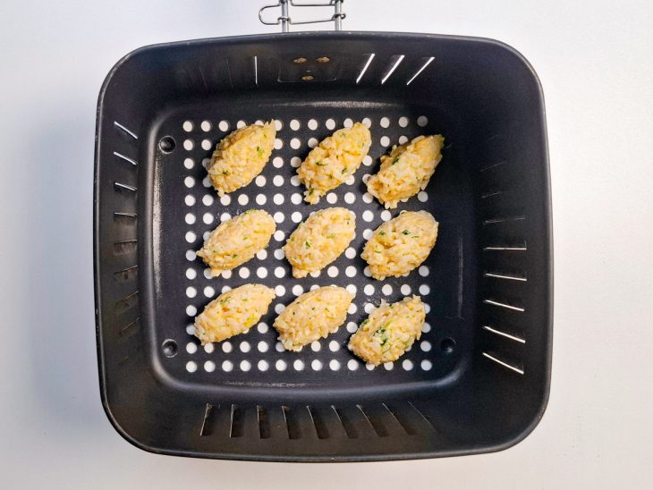 Bolinhos acomodados no cesto da air fryer.