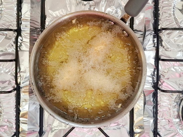 bolinho de arroz fritando na panela com óleo