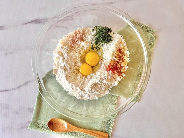Um recipiente contendo arroz, ovos, farinha, sal e temperos.