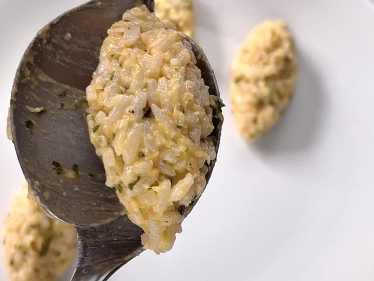 Uma colher modelando os bolinho de arroz.