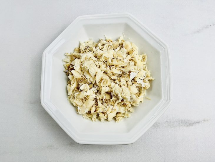 Bacalhau em um prato, desfiado.