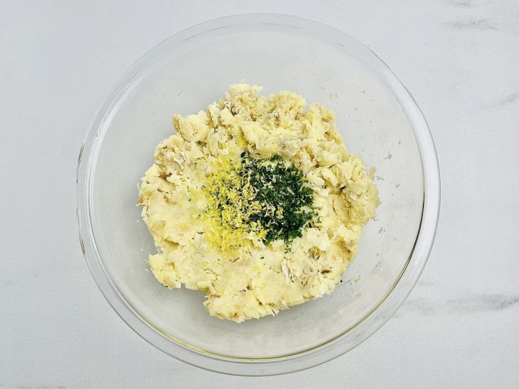 Batatas, bacalhau, e os outros temperos reunidos na tigela.