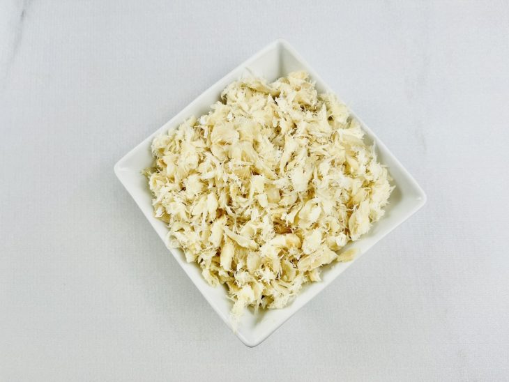 Bacalhau desfiado num recipiente.