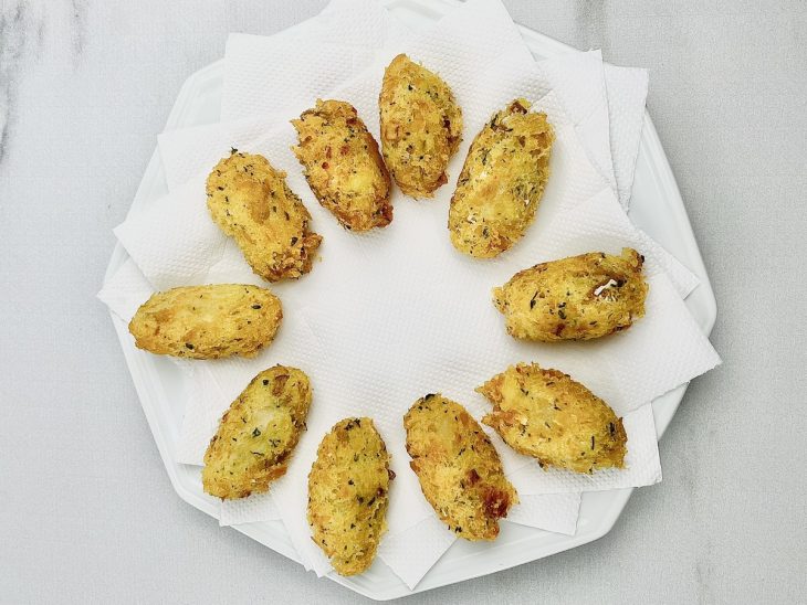 Bolinhos fritos num prato com papel toalha.