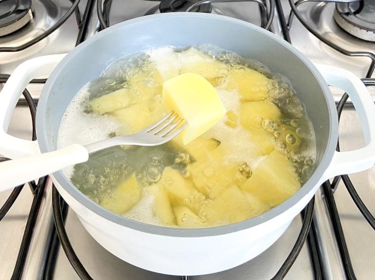 Uma panela com batatas picadas cozinhando.