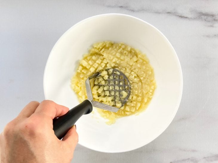 Um recipiente com batatas amassadas.