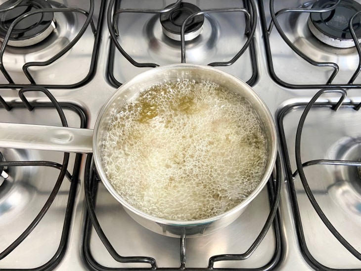 Uma panela contendo óleo quente fritando as bolinhas.