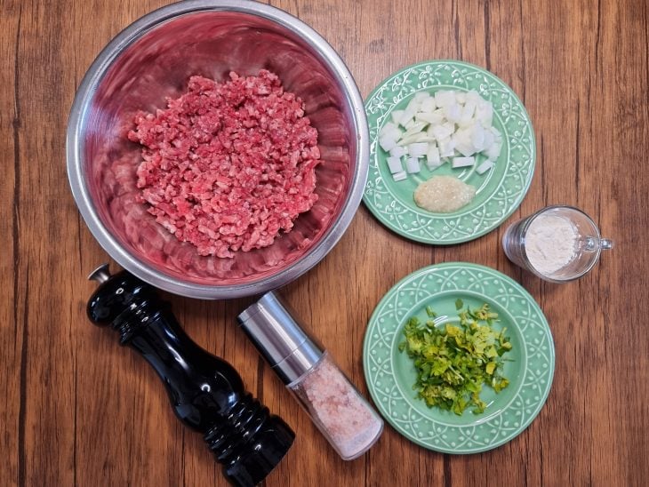 Todos ingredientes do bolinho de carne moída simples reunidos na bancada.