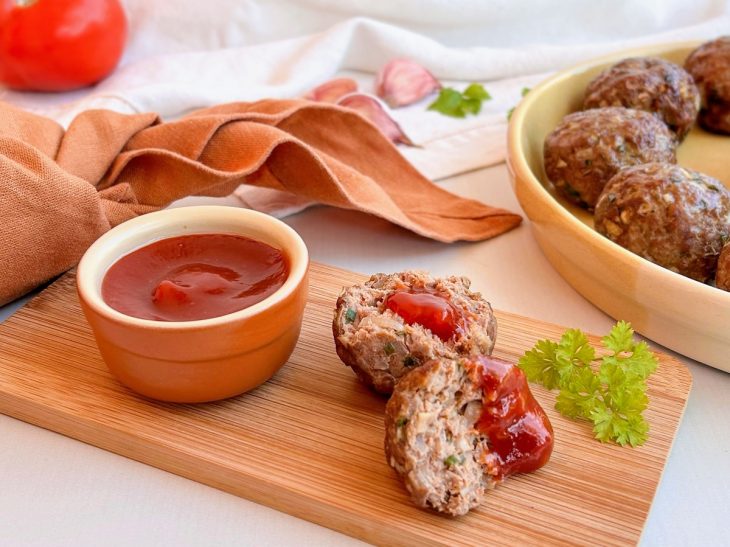 bolinho de carne servido com molho ketchup.
