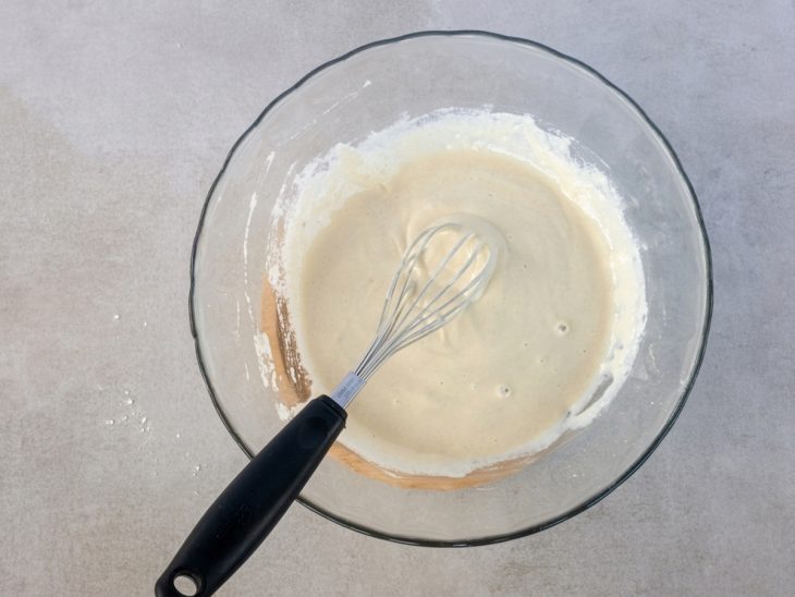 Mistura líquida sendo incorporada aos ingredientes secos formando uma massa.