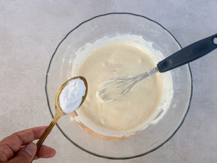 Massa recebendo o fermento e sendo mexida delicadamente.