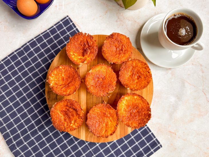Bolinhos prontos, servidos em tábua com café acompanhando.